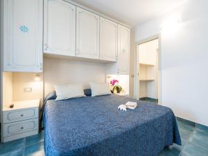 una camera con letto blu e armadi bianchi di Green Village Resort a Villasimius