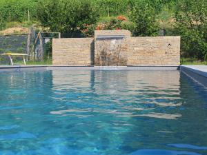 a swimming pool with a water fountain at Agriturismo Cascina L'Arché in Santo Stefano Belbo