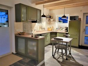 a kitchen with green cabinets and a table and chairs at Haus Theda in Fockbek