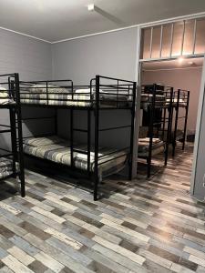 three bunk beds in a room with a floor at Sunraysia Stays in Mildura