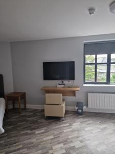 a room with a desk and a television and a chair at Home Inn in Athlone