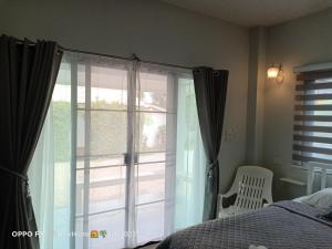 una camera da letto con porta scorrevole in vetro che si apre su una finestra di Min House a Lamphun