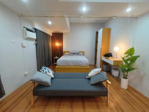 um quarto com duas camas e um sofá em ZSL Elegant Condo LOOP Tower 1 em Cagayan de Oro