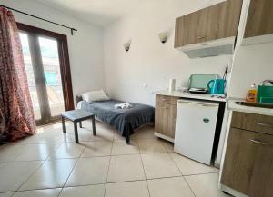 Una pequeña cocina con una cama y una mesa dentro. en Samos - Kokkari - Eirini's Studios, en Kokkari 67 fotos más