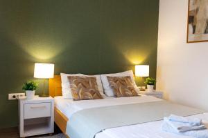 sypialnia z 2 łóżkami i zieloną ścianą w obiekcie Zona Optimizma accommodation & SPA w mieście Vršac