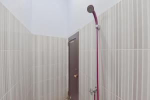 a hallway with a shower with a door and a camera at RedDoorz Syariah near Ramayana Mall Tarakan in Tarakan