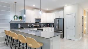 a kitchen with white cabinets and a large island with bar chairs at 1249 Challenge in Davenport