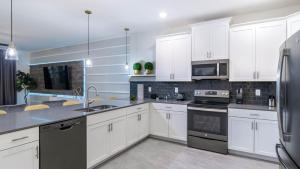 a kitchen with white cabinets and black appliances at 1249 Challenge in Davenport +38 photos