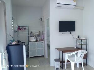 Pokój ze stołem i biurkiem z telewizorem w obiekcie Min House w mieście Lamphun