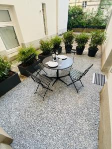 une terrasse avec une table, des chaises et des plantes dans l'établissement 3-Raum Apartment Quartier57 Hamburg-Eppendorf, à Hambourg