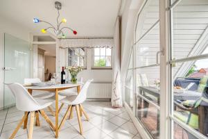a dining room with a table and white chairs at Birkenstraße 15c Whg 9 in Zingst