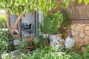 two statues of two geese standing in a garden at Talia Cabin Guest & Spa in Rosh Pinna