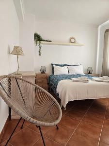a bedroom with a bed and a chair in it at Casa de praia em Almograve in Almograve