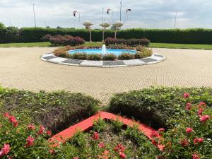 a garden with a fountain with flamingos in it at ibis Styles Milano Est Settala in Settala