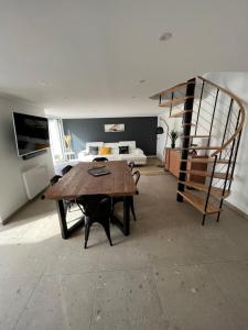 a living room with a wooden table and a staircase at Maison de charme avec jacuzzi - Bretagne / île de Batz in Île de Batz