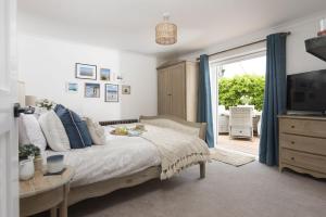 a bedroom with a large bed and a sliding glass door at Chyvounder, Sennen in Trevilley