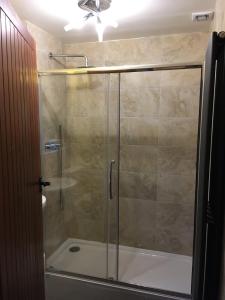 a shower with a glass door and a tub at Low Jock Scar Country Estate in Lake District National Park