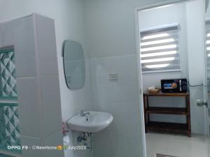 a white bathroom with a sink and a mirror at Min House in Lamphun