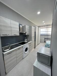 a kitchen with a sink and a washing machine at RICCIARDELLI HOLIDAY HOMES in paese di fronte al Mare in Vieste