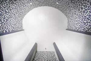 a room with a patterned wall and two benches at Olive Villas Beach Hotel in Sozopol