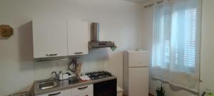 een keuken met een gootsteen, een fornuis en een koelkast bij Mondello Blue Sea in Mondello