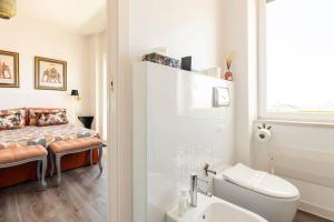La salle de bains est pourvue d'un lavabo et d'un lit dans la chambre. dans l'établissement Eleventh Floor Suites, à Cagliari