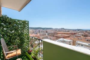 een balkon met een stoel en uitzicht op de stad bij Eleventh Floor Suites in Cagliari