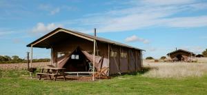 a large tent with a picnic table in a field at College Farm by Feather Down in Beccles