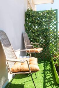 une paire de chaises sur une terrasse avec pelouse verte dans l'établissement Eleventh Floor Suites, à Cagliari