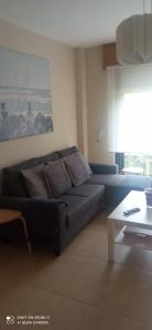 Apartamento Quérote Fisterra1 في فينيستيري: غرفة معيشة مع أريكة سوداء وطاولة