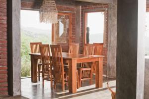 拉布安的住宿－Bukit Cottage Pak Ansel，一间带木桌和椅子的用餐室