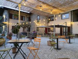 a patio with tables and chairs in a building at Agriturismo Cascina L'Arché in Santo Stefano Belbo