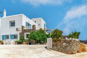 a white villa with a stone wall at Afroditi Ftelia Gerani A in Ftelia