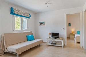 a living room with a couch and a bed and a television at Afroditi Ftelia Gerani A in Ftelia