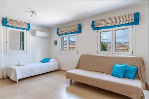 a room with two beds and a couch and windows at Afroditi Ftelia Gerani A in Elia