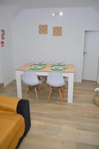 une salle à manger avec une table et deux chaises blanches dans l'établissement Casa dos Albardeiros, à Moura