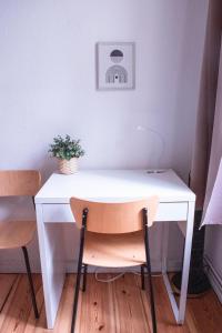 a white desk with a potted plant on top of it at Artsy Room for 2 in Prenzlauer Berg - Ideal Stay in Shared Flat in Berlin