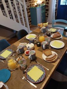 a wooden table with plates of food on it at Chambres d'hôtes Frehel in Fréhel