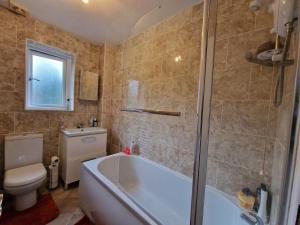 uma casa de banho com uma banheira, um WC e um lavatório. em Nice Living Serviced Accommodations 7 em Rugby
