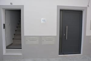 a hallway with a black door and a mirror at Casa dos Albardeiros in Moura