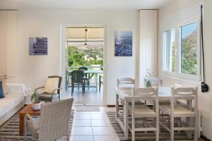 a living room with a white table and chairs at Stunning Views Kantouni Beach in Kalymnos