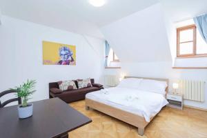 een slaapkamer met een bed, een tafel en een bank bij Beethoven Apartments in Bratislava