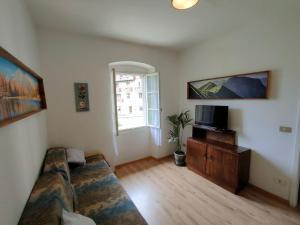 a living room with a couch and a tv at Casa Maria Angela in Ledro