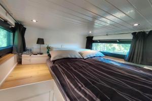 a large bed in the middle of a rv at Tiny House Ithblick direkt am See in Salzhemmendorf