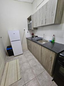 a kitchen with a white refrigerator and a sink at Private Guest Suite with 24hr Electricity, East London in East London
