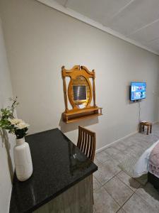 a room with a table with a mirror and a tv at Private Guest Suite with 24hr Electricity, East London in East London