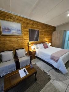 um quarto com 2 camas, uma mesa e um sofá em Private Guest Suite with 24hr Electricity, East London em East London