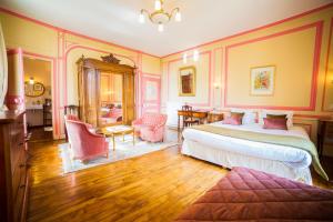 um quarto com 2 camas, uma mesa e cadeiras em Château Hôtel Du Colombier em Saint Malo