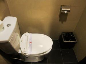 Łazienka z białą toaletą i umywalką w obiekcie Manado Quality Hotel w mieście Manado
