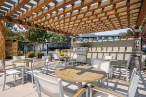 a patio with tables and chairs under a wooden pergola at Mountain View 2BR w Pool Gym BBQ nr Target SFO-623 in Mountain View